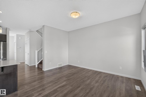 Wood-finish flooring, light grey wall paint, and a built-in staircase with white railings - 1404 25 Avenue Nw, Edmonton, AB - Indoor Photo Showing Other Room