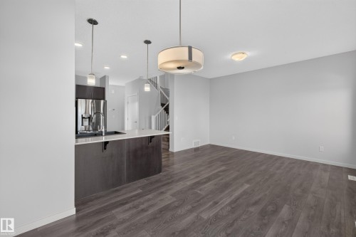 Dark wood-finish flooring, white walls, and a recessed ceiling light - 1404 25 Avenue Nw, Edmonton, AB - Indoor Photo Showing Kitchen