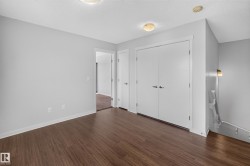 Wood-finish flooring, light gray wall paint, white trim, and a white bi-fold closet door - 