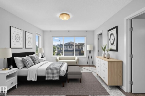 Recessed ceiling light fixture, white walls, large window with white trim, wood-finish flooring, and white interior doors - 1404 25 Avenue Nw, Edmonton, AB - Indoor Photo Showing Bedroom