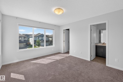 Bright interiors with neutral wall tones, plush carpeting, and a flush mount ceiling fixture - 1404 25 Avenue Nw, Edmonton, AB - Indoor