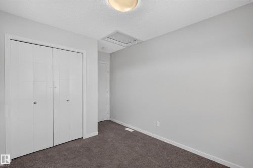 Recessed ceiling light, carpeted flooring, white bi-fold closet doors, white trim, and light gray wall paint - 1404 25 Avenue Nw, Edmonton, AB - Indoor Photo Showing Other Room