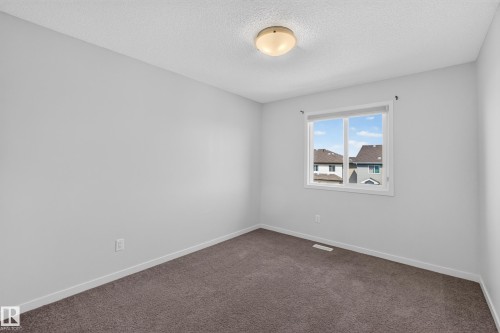 Carpeted flooring, neutral wall tones, white trim, and a flush-mount ceiling light fixture - 1404 25 Avenue Nw, Edmonton, AB - Indoor Photo Showing Other Room