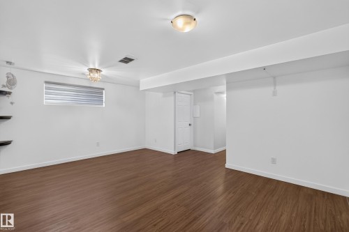 Recessed window with horizontal blinds, wood-finish flooring, and white walls - 1404 25 Avenue Nw, Edmonton, AB - Indoor