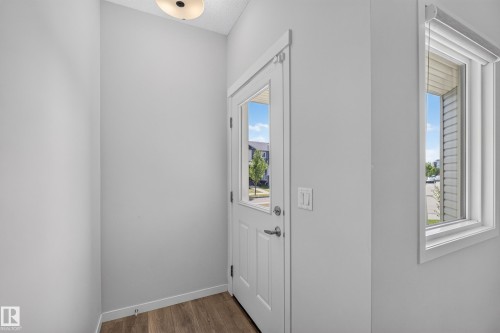 Frosted glass ceiling light fixture, wood-finish flooring, and white interior walls - 1404 25 Avenue Nw, Edmonton, AB - Indoor Photo Showing Other Room