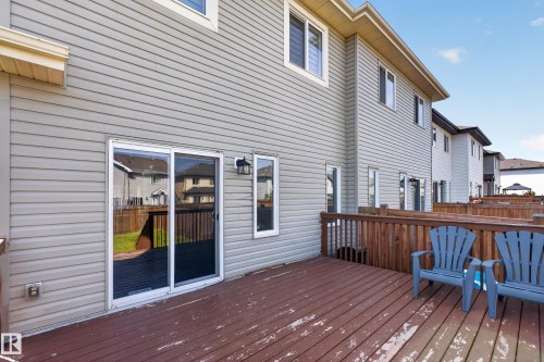 Expansive wood-finish deck with a wood railing, sliding glass door, and exterior wall lantern - 1404 25 Avenue Nw, Edmonton, AB - Outdoor With Deck Patio Veranda With Exterior