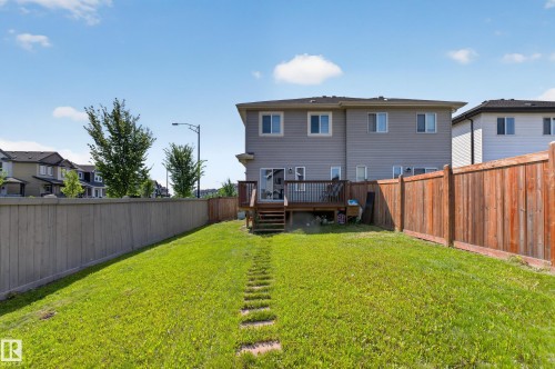 Expansive fenced backyard featuring a wood deck, wood privacy fencing, and a stone-stepped path - 1404 25 Avenue Nw, Edmonton, AB - Outdoor With Deck Patio Veranda