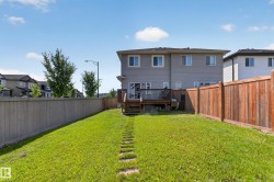 Expansive fenced backyard featuring a wood deck, wood privacy fencing, and a stone-stepped path - 