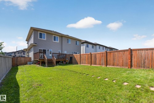 Expansive backyard featuring a manicured lawn, a wooden deck, and full privacy fencing - 1404 25 Avenue Nw, Edmonton, AB - Outdoor With Deck Patio Veranda With Backyard With Exterior