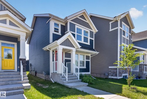 Two-story residence featuring a covered front porch, white railings, and a red entry door - 749 Southfork Drive, Leduc, AB - Outdoor With Facade