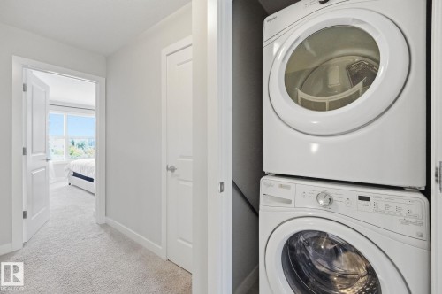 Upstairs laundry features a stacked washer and dryer. - 1793 Keene Crescent Sw, Edmonton, AB - Indoor Photo Showing Laundry Room