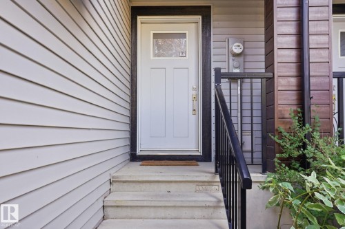 Light gray horizontal siding with a white panel door and clear glass insert - 1793 Keene Crescent Sw, Edmonton, AB - Outdoor With Exterior