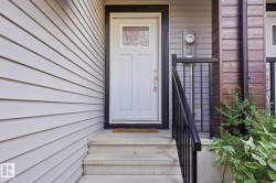 Light gray horizontal siding with a white panel door and clear glass insert - 