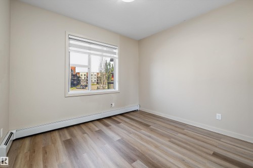 Wood-finish flooring, neutral wall tones, and a window with blinds - #207 304 Amblside Li Sw Sw, Edmonton, AB - Indoor Photo Showing Other Room