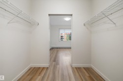 Walk-through closet with wire shelving and wood-finish flooring - 