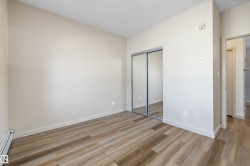 Wood-finish flooring, mirrored closet doors, and light-toned walls - 