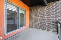 Concrete balcony with a dark brick wall and an orange stucco accent wall - 