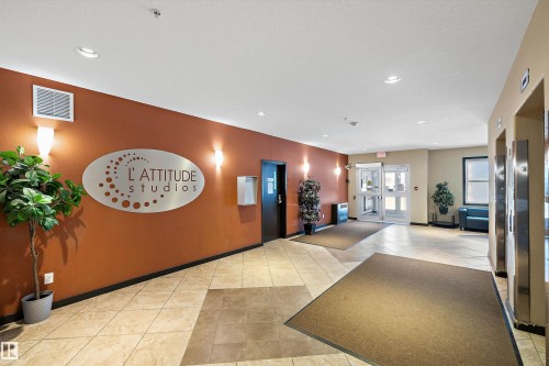 Tiled flooring throughout the common area, featuring wall-mounted sconce lighting and recessed ceiling lights - #207 304 Amblside Li Sw Sw, Edmonton, AB - Indoor Photo Showing Other Room