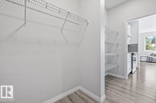 Wire shelving, wood-finish flooring, white trim, open doorway, white walls - 1014 Daniels Loop Sw, Edmonton, AB - Indoor With Storage