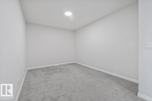 Recessed ceiling lighting, light gray wall paint, gray carpeting, and white baseboards - 1014 Daniels Loop Sw, Edmonton, AB - Indoor Photo Showing Other Room
