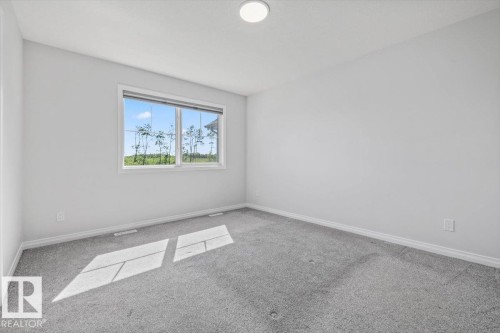 Gray carpeting, white walls, and a prominent window - 1014 Daniels Loop Sw, Edmonton, AB - Indoor Photo Showing Other Room