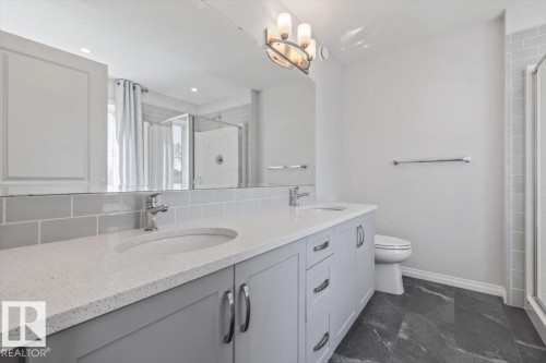 Double vanity with light gray cabinetry, integrated sinks, and polished chrome fixtures - 1014 Daniels Loop Sw, Edmonton, AB - Indoor Photo Showing Bathroom