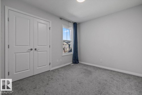 Light gray wall paint, gray carpet, white trim, and a flush-mount ceiling light - 1014 Daniels Loop Sw, Edmonton, AB - Indoor Photo Showing Other Room