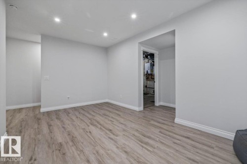 Recessed lighting illuminating light gray walls, wood-finish flooring, and white trim - 1014 Daniels Loop Sw, Edmonton, AB - Indoor Photo Showing Other Room
