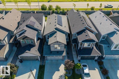 Modern two-story residence featuring a dark shingle roof, solar panels, and a single-car garage - 1014 Daniels Loop Sw, Edmonton, AB - Outdoor