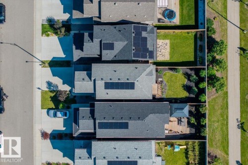 Rooftop solar panels, asphalt shingle roofing, paved driveways, and manicured lawns - 1014 Daniels Loop Sw, Edmonton, AB - 
