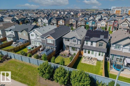 Modern residential development featuring various architectural styles, private fenced yards, and a paved pathway - 1014 Daniels Loop Sw, Edmonton, AB - Outdoor