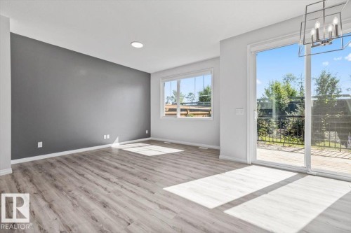 Wood-finish flooring, recessed lighting, and a window with a white frame - 1014 Daniels Loop Sw, Edmonton, AB - Indoor Photo Showing Other Room