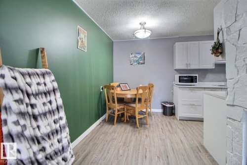 Kitchenette featuring light-toned cabinetry, a built-in microwave, and stone-look countertops - #304 14004 26 St Nw, Edmonton, AB - Indoor