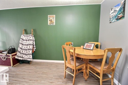 Wood-finish flooring with varying tones, green and gray painted walls, and white trim - #304 14004 26 St Nw, Edmonton, AB - Indoor