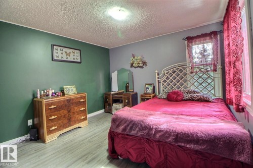 Light wood-finish flooring with painted walls and a ceiling-mounted light fixture - #304 14004 26 St Nw, Edmonton, AB - Indoor Photo Showing Bedroom