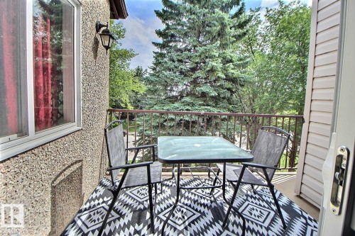 Exterior balcony with metal railing, textured exterior wall, and outdoor wall sconce - #304 14004 26 St Nw, Edmonton, AB - Outdoor With Deck Patio Veranda With Exterior