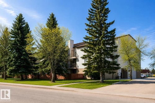 Three-story exterior with balconies, surrounded by mature trees and manicured lawns - #304 14004 26 St Nw, Edmonton, AB - Outdoor
