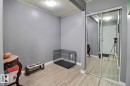 Wood-finish flooring with neutral wall paint and mirrored closet doors - #304 14004 26 St Nw, Edmonton, AB  - Indoor Photo Showing Other Room 