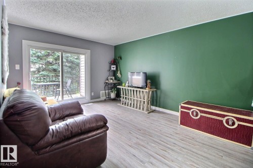 Wood-finish flooring throughout, with a sliding glass door leading to an outdoor balcony - #304 14004 26 St Nw, Edmonton, AB - Indoor