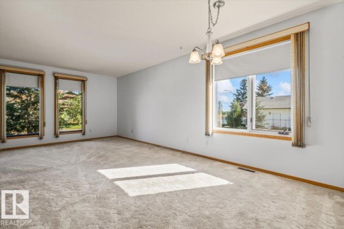 Expansive room with neutral carpeting, multiple large windows, and a ceiling-mounted light fixture - 4427 Payne Avenue, Onoway, AB - Indoor Photo Showing Other Room