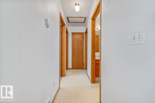 Hallway with light-toned wall finishes, wood-finish door frames, and ceiling-mounted lighting - 4427 Payne Avenue, Onoway, AB - Indoor Photo Showing Other Room