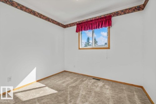 Window with wood trim, carpeted flooring, and crown molding - 4427 Payne Avenue, Onoway, AB - Indoor Photo Showing Other Room