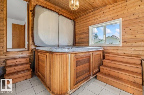 Indoor hot tub with wood-paneled surround, natural wood-plank walls, and a tiled floor - 4427 Payne Avenue, Onoway, AB - Indoor Photo Showing Other Room