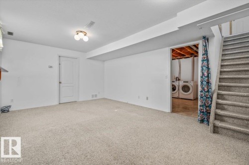 Carpeted floor, white painted walls, ceiling-mounted light fixture, interior door, and carpeted staircase - 4427 Payne Avenue, Onoway, AB - Indoor Photo Showing Other Room