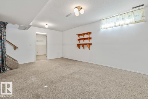 Carpeted floor, wood shelves, overhead light fixtures, and an interior doorway leading to an additional space - 4427 Payne Avenue, Onoway, AB - Indoor Photo Showing Other Room