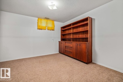 Built-in wood-finish shelving and cabinetry with ample storage, a window, and overhead lighting - 4427 Payne Avenue, Onoway, AB - Indoor Photo Showing Other Room
