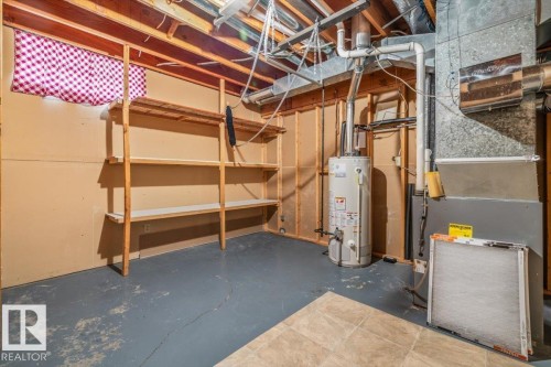 Storage area featuring exposed ceiling joists, wood shelving, and painted concrete flooring - 4427 Payne Avenue, Onoway, AB - Indoor Photo Showing Basement