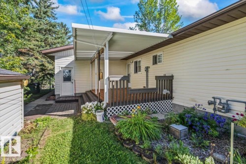 Covered deck with dark wood-finish railing, light-colored siding, and a brick paver pathway - 4427 Payne Avenue, Onoway, AB - Outdoor With Deck Patio Veranda With Exterior
