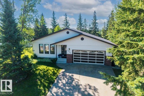 White siding exterior with a dark-paneled garage door - 4427 Payne Avenue, Onoway, AB - Outdoor