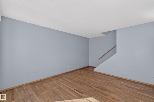 Hardwood flooring, painted walls, and a wooden handrail - 23 Willowdale Place Nw, Edmonton, AB 